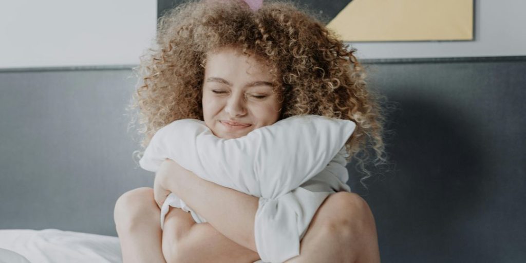 Chica abraza a su almohada